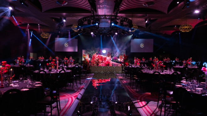large function room with stage, flowers and dramatic lighting